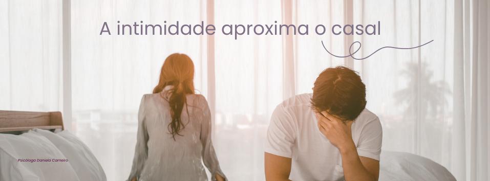 Casal sentado na cama, afastados e visivelmente abalados, representando a falta de intimidade e a desconexão emocional no relacionamento.