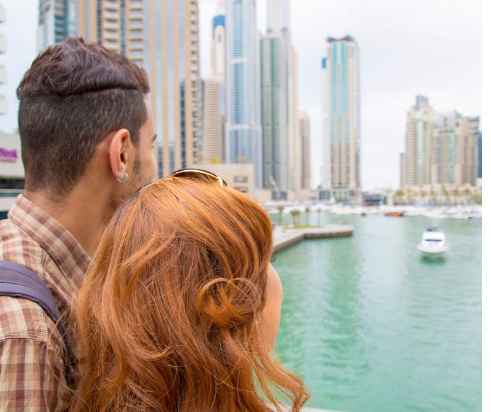 Casal brasileiro caminhando em Dubai, enfrentando desafios no relacionamento.