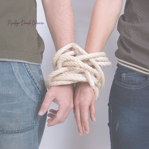 casal com braços atados por cordas indicando dependência emocional